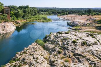 Travel to Provence, France - stone riverbank of of Gardon River near Pont du Gard near Vers-Pont-du-Gard town
