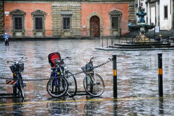 travel to Italy - wet bicycles on piazza della santissima annunziata in Florence city in winter rainy day