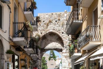 TAORMINA, ITALY - JUNE 29, 2017: medieval arch of old gateway Porta Catania in Taormina city. Taormina is resort town on Ionian Sea in Sicily
