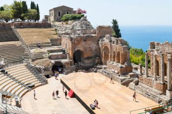 TAORMINA, ITALY - JUNE 29, 2017: visitors in Teatro antico di Taormina, ancient Greek Theater (Teatro Greco) in Taormina city in summer day. The amphitheater was built in the third century BC
