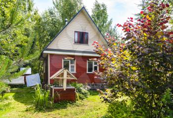 typical cottage and well on backyard in russian village in sunny summer day