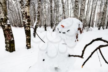 smiling snowman in birch grove of Timiryazevskiy park in Moscow city in winter