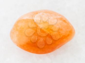 macro shooting of natural mineral rock specimen - tumbled yellow aventurine gemstone on white marble background from India