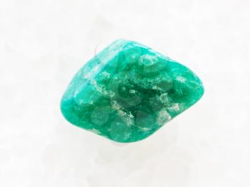 macro shooting of natural mineral rock specimen - tumbled amazonite gemstone on white marble background from Brazil