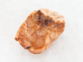 macro shooting of natural mineral rock specimen - rough orthoclase stone on white marble background