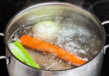 cooking soup - boiling meat broth in stew pan close up