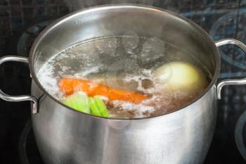 cooking soup - boiling meat broth in steel stockpot