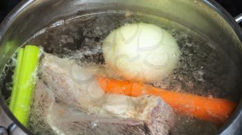 cooking soup - boiling beef stock in stewpan close up