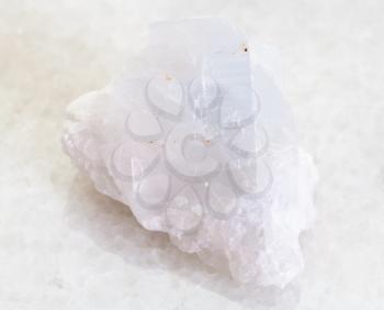 macro shooting of natural mineral rock specimen - rough crystalline Magnesite stone on white marble background