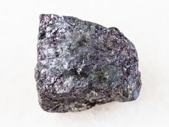 macro shooting of natural mineral rock specimen - piece of bornite stone on white marble background from Azerbaijan