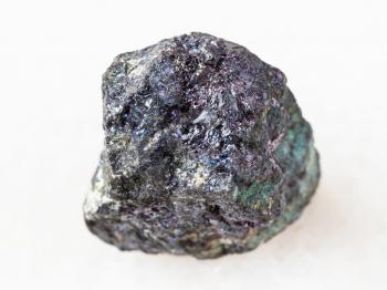 macro shooting of natural mineral rock specimen - pebble of bornite stone on white marble background from Azerbaijan