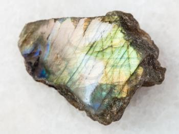 macro shooting of natural mineral rock specimen - polished slab of labradorite stone on white marble background from Finland