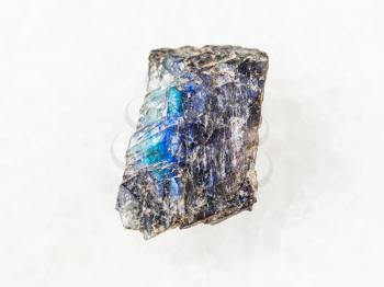 macro shooting of natural mineral rock specimen - raw labradorite stone on white marble background from Finland