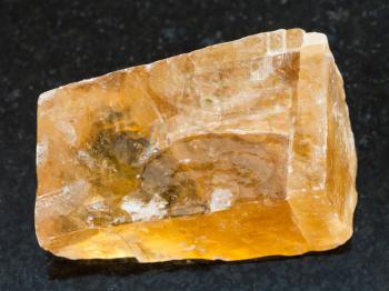 macro shooting of natural mineral rock specimen - raw tea Calcite stone on dark granite background from Mexico