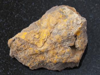 macro shooting of natural mineral rock specimen - rough limonite stone on dark granite background from Olkhinskoye mine, Irkutsk region, Russia