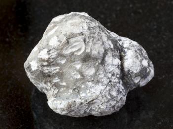macro shooting of natural mineral rock specimen - native cacholong stone on dark granite background from Kazakhstan