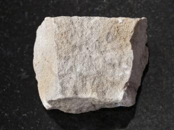 macro shooting of natural mineral rock specimen - raw gray Dolomite stone on dark granite background