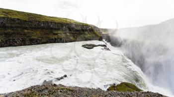 travel to Iceland - flow of Gullfoss waterfall and water spray over canyon of Olfusa river in september