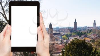 travel concept - tourist photographs Verona city skyline in spring on tablet with cut out screen for advertising logo