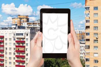 travel concept - tourist photographs residential quarter in Moscow city in Russia in summer on tablet with cut out screen for advertising logo