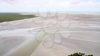 Travel to France - above view of silted tidal bay in low tide around Le Mont Saint-Michel island in Normandy