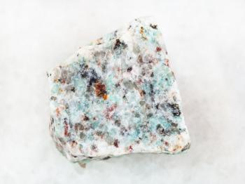 macro shooting of natural mineral rock specimen - raw amazonite granite stone on white marble background