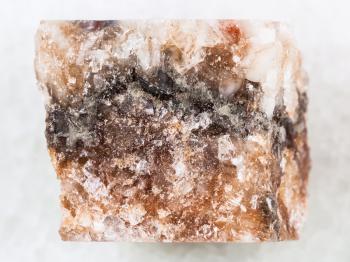 macro shooting of natural mineral rock specimen - raw rock salt halite on white marble background from Solikamsk region in Perm Krai, Russia