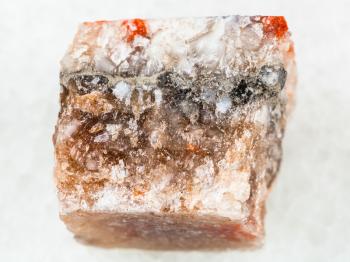 macro shooting of natural mineral rock specimen - rough rock salt halite on white marble background from Solikamsk region in Perm Krai, Russia