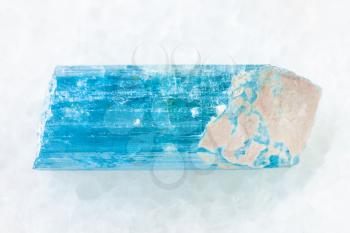 macro shooting of natural mineral rock specimen - raw crystal of aquamarine (blue beryl) gemstone on white marble background from Sherlova Gora (Sherlovaya Gora) mine, Transbaikalia, Russia