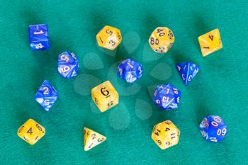 two sets of polyhedral dices for Dungeons and Dragons board game playing on green baize table