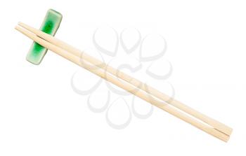 top view of disposable wooden chopsticks served on chopstick rest isolated on white background