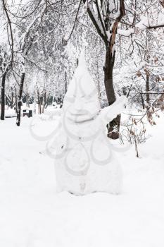 snowman in public urban garden in Moscow city in winter snowfall