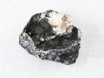 macro shooting of natural mineral - rough Hematite crystal on white marble from Central Ural Mountains