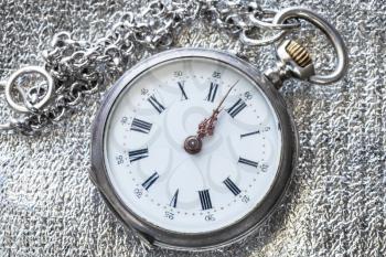 retro pocket watch on silver fabric background close up