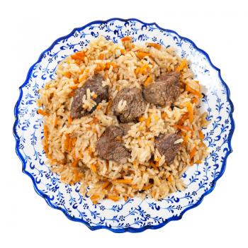 top view of prepared pilau (central asian dish from rice with meat and vegetable) on local ceramic plate isolated on white background