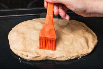 cooking of pie - oiling the raw pie by silicone brush