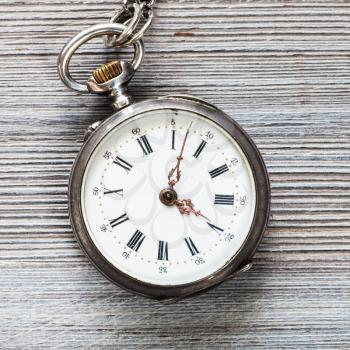 old pocket watch on gray wooden background close up