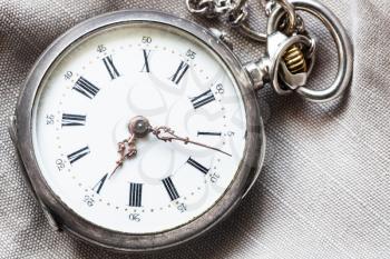 antique pocket watch on gray textile background close up