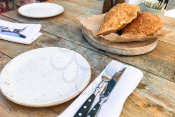 travel to Caucasian Mineral Waters region - empty ceramic plate and chebureki dish in local restaurant in Kislovodsk resort town