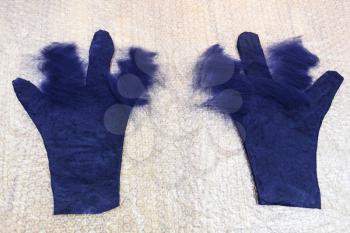 workshop of hand making a fleece gloves from blue Merino sheep wool using wet felting process - partly shaped with cutting pattern wet gloves with new layer of fibers on fingers