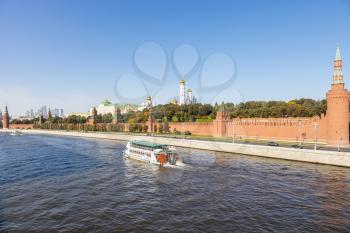 view of Moskva river with excursion boat near Kremlin embankment from Bolshoy Moskvoretsky Bridge on sunny autumn day