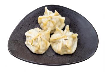 steamed Buuz (Mongolian dumpling filled with minced meat) on black plate isolated on white background
