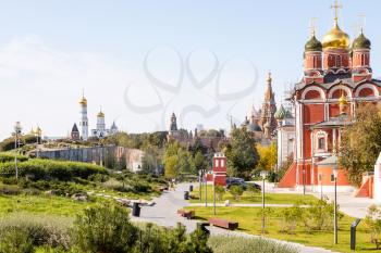 cathedral of Znamensky monastery in the Old Tsar's yard in Zaryadye urban landscape public park on Varvarka street and view of Kremlin on background in Moscow city on sunny September day