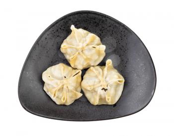 top view of steamed Buuz (Mongolian dumpling filled with minced meat) on black plate isolated on white background