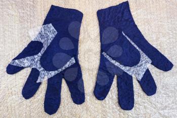 workshop of hand making a fleece gloves from blue Merino sheep wool using wet felting process - wet felted gloves before fulling