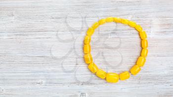 top view of vintage yellow amber necklace on gray wooden board with copyspace
