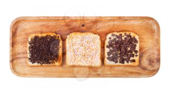 top view of various dutch sweet open sandwich with toast and toppings from chocolate sprinkles on wooden plate isolated on white background