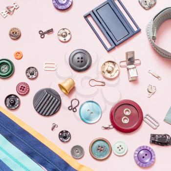 top view of set of various sewing accessories on pink background