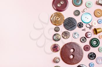 top view of various sewing items on pink background with blank copyspace