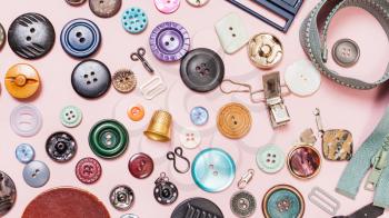 top view of many various sewing objects on pink background